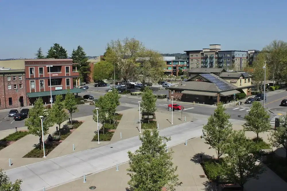 Auburn station plaza with brick buildings and young trees seen from the parking garage in Auburn, Washington