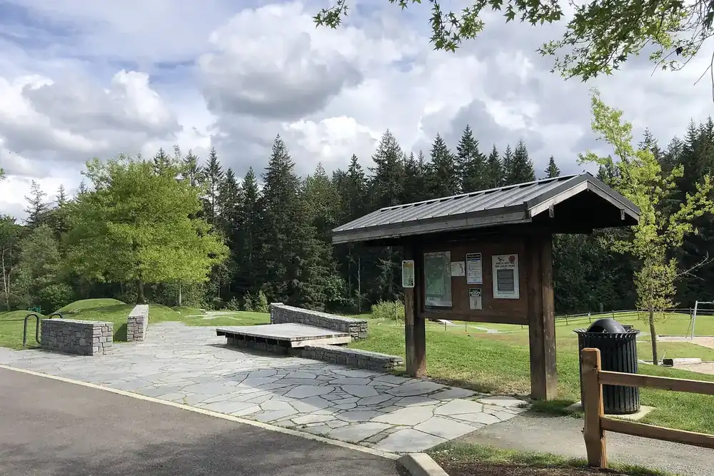 Covered information kiosk and stone benches at Big Rock Park in Sammamish, Washington